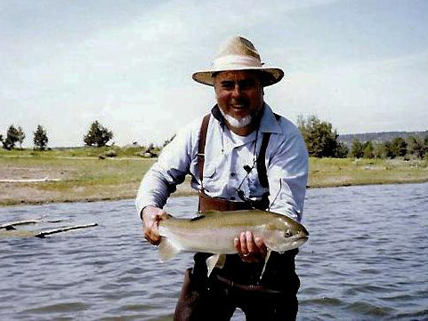 Man in waders holding large fish